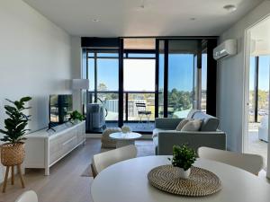 sala de estar con sofá y mesa en Skygarden Luxury Condo en Glen Waverley