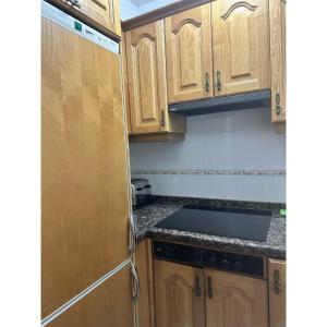 a kitchen with wooden cabinets and a stove top oven at Casa Rural El Torrejon in Arenas de Cabrales +12 photos