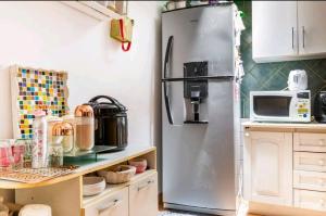 a stainless steel refrigerator in a kitchen with a microwave at Oasis casa da melody in Munro