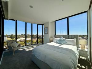 1 dormitorio con 1 cama grande y ventanas grandes en Skygarden Luxury Condo, en Glen Waverley