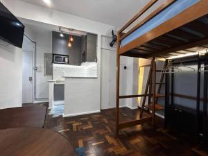 een kleine kamer met een hoogslaper en een keuken bij Loft Master Coração Centro Histórico livre de enchentes in Porto Alegre