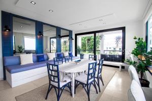 a dining room with a table and chairs and a couch at Villa Azure Ocean Park's Seaside Luxe Retreat in San Juan