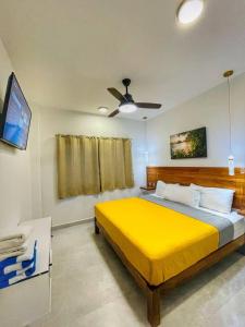 a bedroom with a yellow bed and a ceiling fan at CASA SAN AGUSTÍN #4 in Puerto Escondido +56 photos
