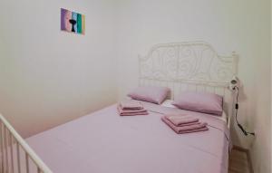 uma cama branca com toalhas cor-de-rosa em Cozy Home In Benkovac With Outdoor Swimming Pool em Benkovac