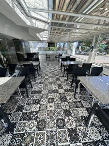 ein Restaurant mit Tischen und Stühlen und Fliesenboden in der Unterkunft Lara Kapris Hotel in Antalya