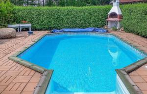 a large blue swimming pool on a brick patio at Gorgeous Home In Gemla With Private Swimming Pool, Can Be Inside Or Outside in Gemla