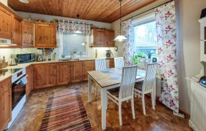 a kitchen with wooden cabinets and a table and chairs at Gorgeous Home In Gemla With Private Swimming Pool, Can Be Inside Or Outside in Gemla