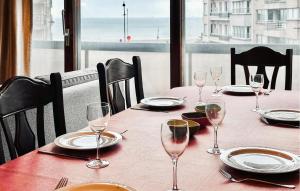 stolik z kieliszkami do wina i talerzami oraz widok na ocean w obiekcie 2 Bedroom Cozy Apartment In Blankenberge w mieście Blankenberge