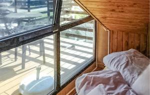 a room with a bed and a window with a balcony at Awesome Apartment In Leba With Sauna in Łeba +2 photos