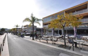 ボルム・レ・ミモザにあるAwesome Apartment In Bormes-Les-Mimosasのテーブルと椅子、座席の人々が並ぶ通り