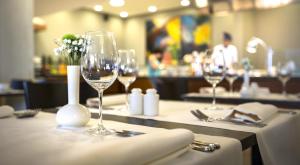 a table in a restaurant with wine glasses and napkins at Hotel Excelsior - Liburnia in Lovran