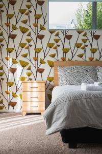 1 dormitorio con cama y pared con estampado de flores en Urban Sanctuary on Union, en Dunedin