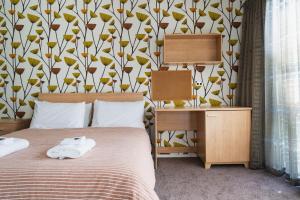 um quarto com uma cama com toalhas brancas em Urban Sanctuary on Union em Dunedin