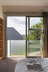 um quarto com uma grande janela com toalhas numa cama em Urban Sanctuary on Union em Dunedin