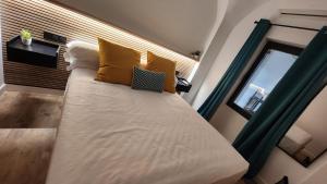 a bedroom with a large bed with yellow pillows at Bailén 3 in Cáceres