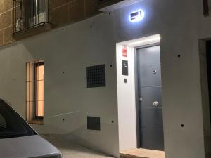 een deur met een licht aan de zijkant van een gebouw bij Bailén 3 in Cáceres