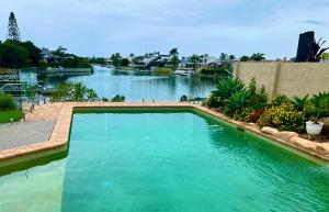 a large swimming pool in front of a river at Waterfront BNB in Gold Coast