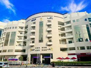 a white building with the akhtar hotel at AlRaef Luxury Apartments in Dubai
