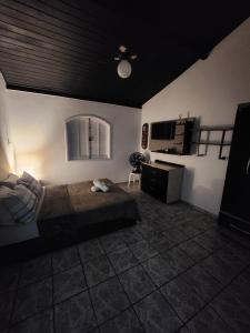 um quarto com uma cama grande e uma cozinha em CaliForte House em Cabo Frio