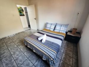 um quarto com uma cama com sapatos brancos em CaliForte House em Cabo Frio