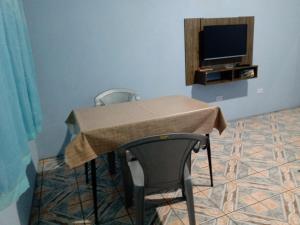 uma mesa com duas cadeiras e uma televisão num quarto em Quarto familiar, aeroporto Guarulhos em Guarulhos