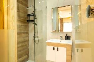 een badkamer met een douche, een wastafel en een spiegel bij Appartement de Luxe à Tanger in Tanger