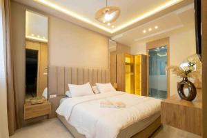 een slaapkamer met een groot wit bed en een spiegel bij Appartement de Luxe à Tanger in Tanger