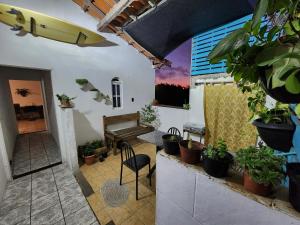 um quarto com vasos de plantas e uma mesa e um banco em CaliForte House em Cabo Frio