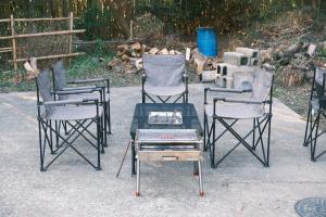 a group of three chairs and a glass table at 一軒家貸切 ARUYOguesthouse BBQと焚き火ができる宿 