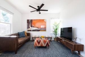 a living room with a couch and a flat screen tv at * Bueno Bueno Casita * / 7 min to Downtown / 4 Bdr in San Diego