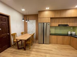 a kitchen with a wooden table and a stainless steel refrigerator at Căn Hộ Chung cư Hưng Phú in Can Tho