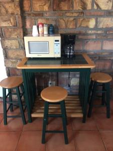 isla de cocina con microondas y 2 taburetes en apartamento tony Chumpos, en San Felipe