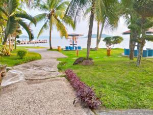 einen Fußweg neben einem Strand mit Palmen in der Unterkunft Hotel Wisata Indah Sibolga in Sibolga