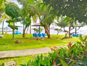 een park bij het water met bomen en een gebouw bij Hotel Wisata Indah Sibolga in Sibolga