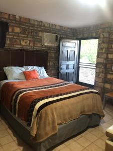 1 dormitorio con cama y pared de ladrillo en apartamento tony Chumpos, en San Felipe