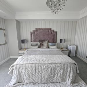 Un dormitorio con una cama grande y una lámpara de araña. en Olympic Residence, en Ulán Bator