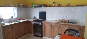 a kitchen with wooden cabinets and a stove top oven at Hostal Adelita in Moisés Ville