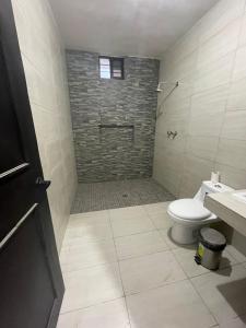 a bathroom with a toilet and a stone wall at Casa de las estrellas in Valles