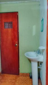 a bathroom with a red door and a sink at Alojamiento Don Luis in Popayan