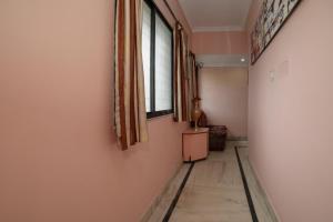 a hallway with a window and a wooden floor at SPOT ON Shraddha Hotel in Nagpur