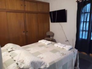 um quarto com uma cama e uma televisão na parede em Vacaciones familiares em La Cieneguita