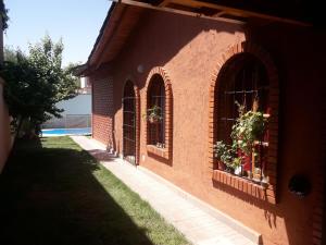 um edifício de tijolos com duas janelas com plantas em Vacaciones familiares em La Cieneguita