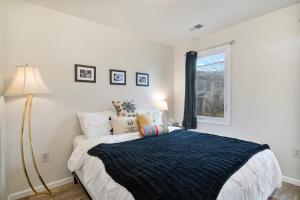 um quarto branco com uma cama e uma janela em USNA Home Downtown Annapolis em Annapolis
