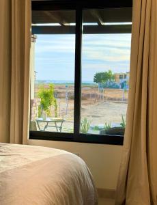 een slaapkamer met een raam met uitzicht op een veld bij Brand NEW Casita Clásica in El Pescadero