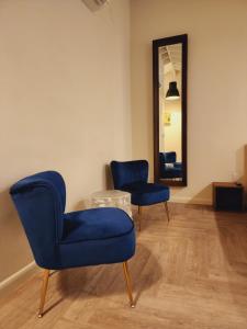 Zimmer mit 2 blauen Stühlen und einem Spiegel in der Unterkunft Private Home Studio Central Located in Miami 2 in Opa-locka