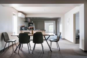a kitchen and dining room with a table and chairs at Apartment on Manor in Dunedin