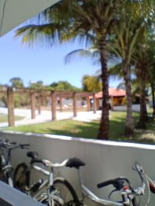 zwei Fahrräder, die an einer Wand mit Palmen geparkt sind in der Unterkunft Pousada Villa do Mar in Itaparica Town