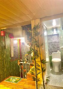 a bathroom with a toilet and a plant in it at Old Building 1939 in Hanoi