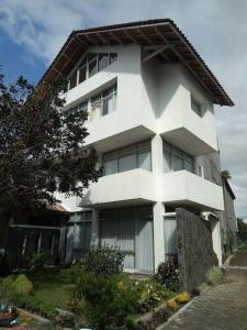 a large white building with a tree in front of it at Rumah cantik di komplek pesantren daarut tauhid in Bandung
