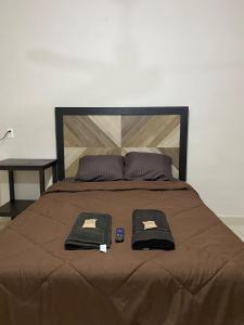 ein Bett mit zwei schwarzen Handtüchern darüber in der Unterkunft ESTUDIO VACACIONAL in Cozumel